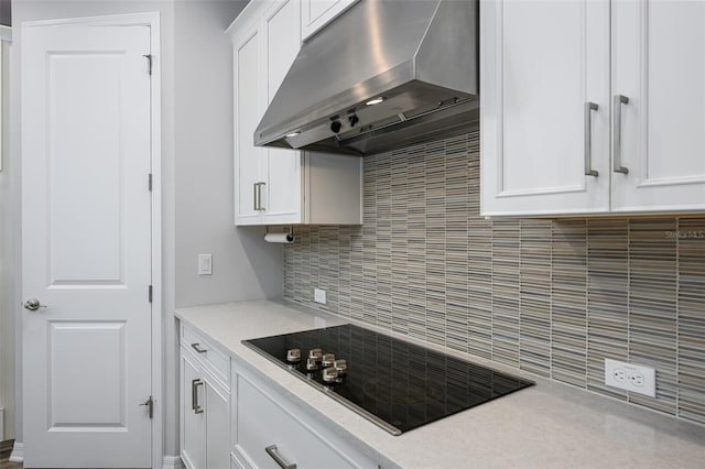 kitchen with black electric cooktop, tasteful backsplash, extractor fan, and white cabinets