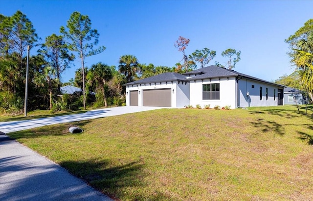 view of front facade featuring a garage, stucco siding, driveway, and a front yard