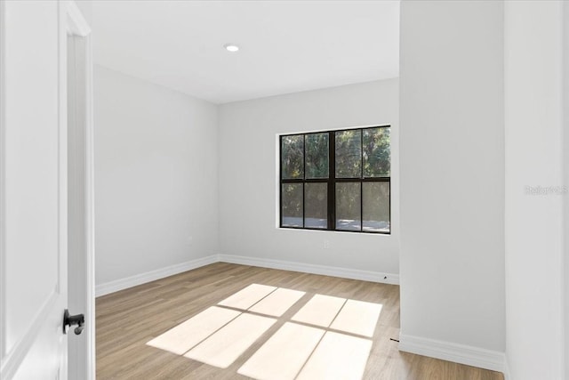 empty room featuring recessed lighting, baseboards, and wood finished floors