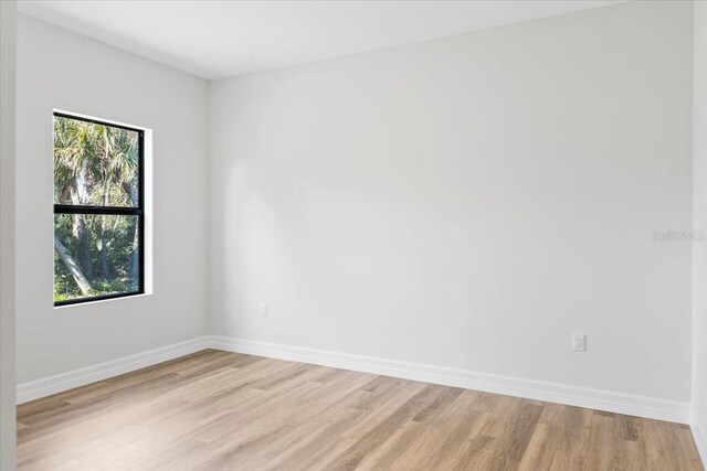 empty room featuring baseboards and light wood-style floors