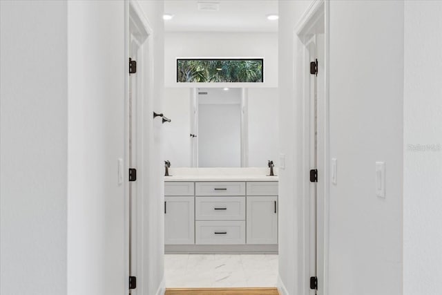 full bathroom featuring double vanity, marble finish floor, and a sink