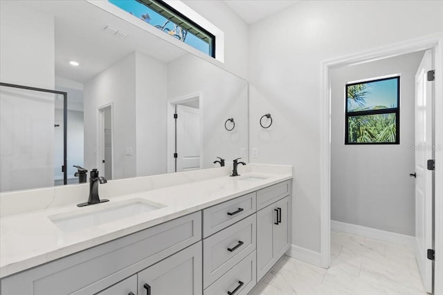 full bath featuring marble finish floor, a wealth of natural light, and a sink