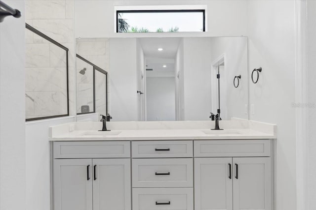 full bath featuring double vanity, a stall shower, and a sink