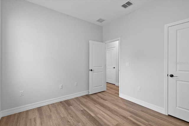 unfurnished bedroom featuring visible vents, baseboards, and wood finished floors