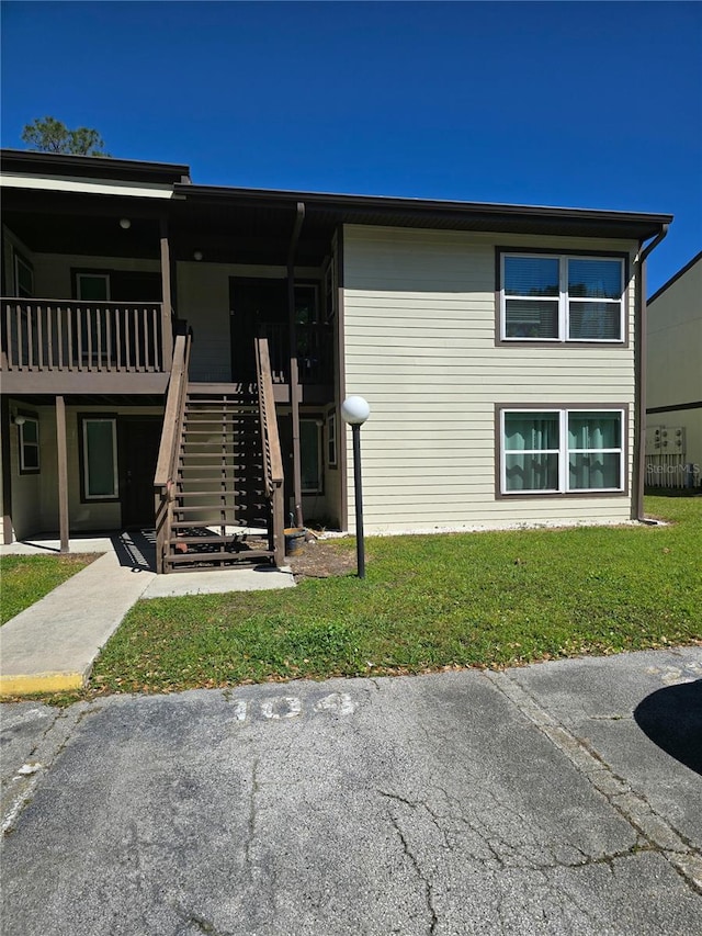 view of front of house featuring stairs and a front yard