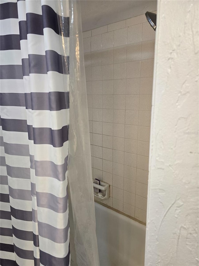 full bathroom featuring shower / bath combo and a textured wall