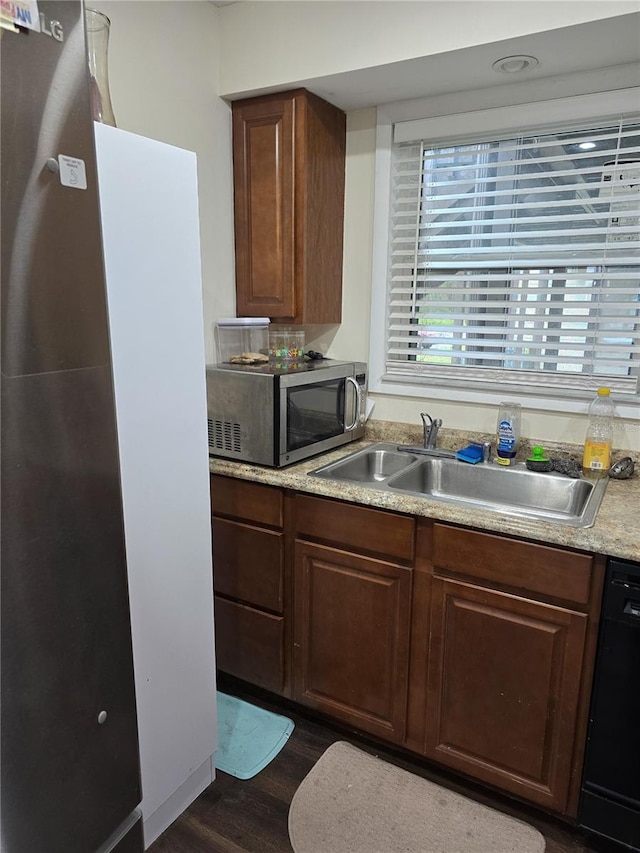 kitchen with dark wood finished floors, appliances with stainless steel finishes, light countertops, and a sink