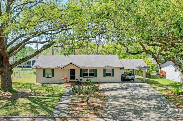 single story home with a carport, concrete driveway, fence, and a front yard