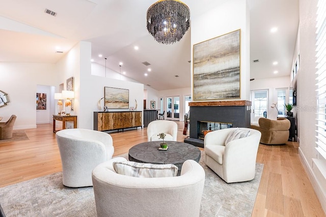 living area featuring visible vents, high vaulted ceiling, light wood-style flooring, recessed lighting, and a multi sided fireplace