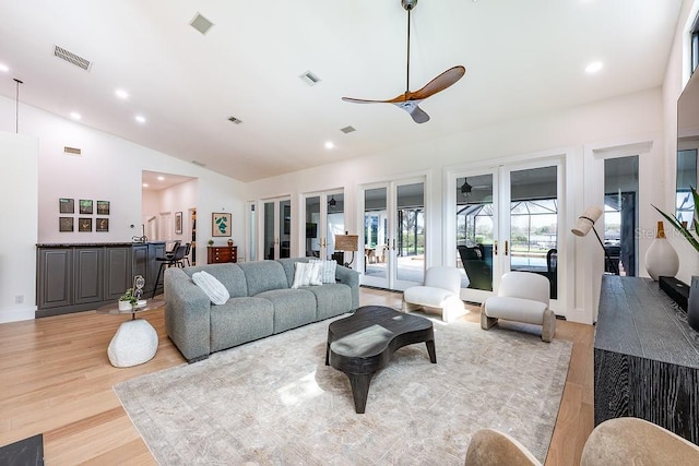 living room with visible vents, ceiling fan, french doors, and vaulted ceiling