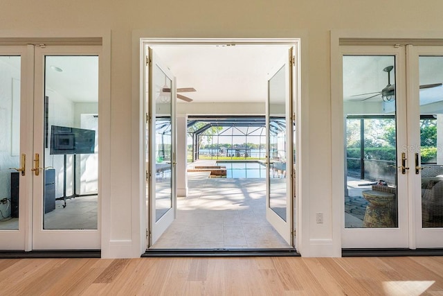 entryway featuring french doors, a ceiling fan, and wood finished floors