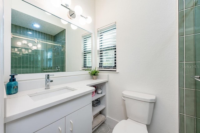 bathroom with vanity, toilet, and a tile shower