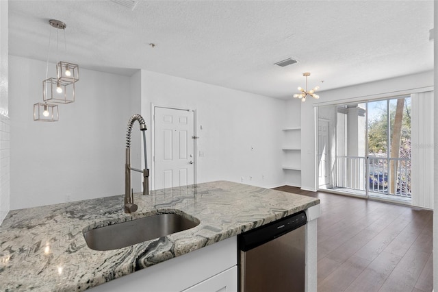 kitchen featuring a textured ceiling, visible vents, dishwasher, wood finished floors, and a sink