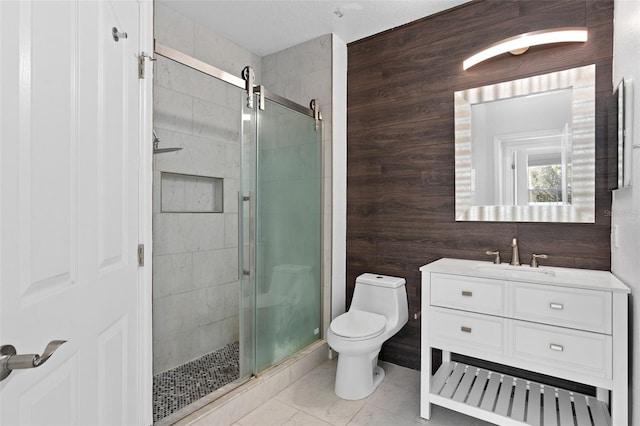 bathroom with toilet, vanity, a stall shower, and wooden walls
