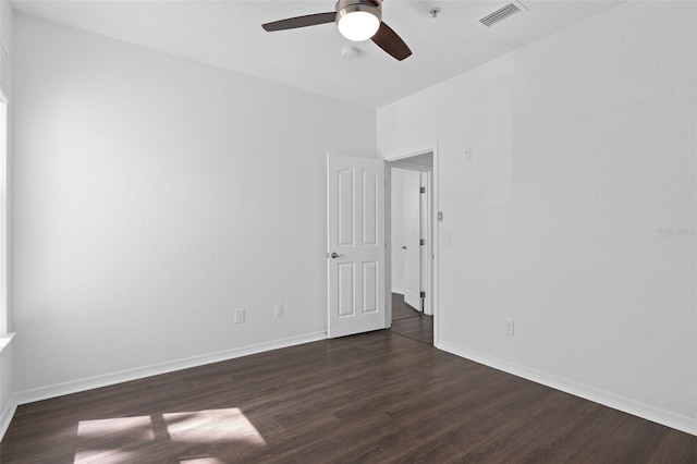 unfurnished room with dark wood-type flooring, baseboards, ceiling fan, and visible vents
