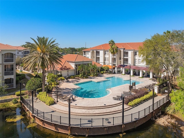 pool featuring a water view and a patio