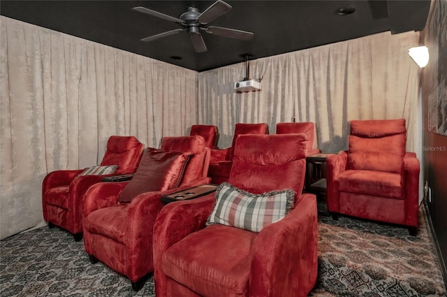 carpeted home theater room featuring wooden walls and ceiling fan