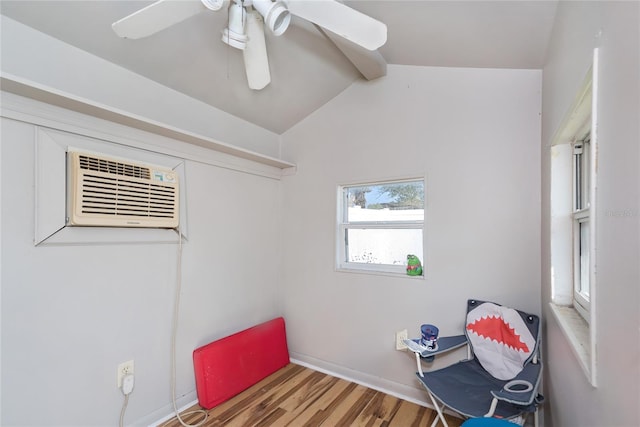 interior space featuring vaulted ceiling with beams, an AC wall unit, a ceiling fan, and wood finished floors