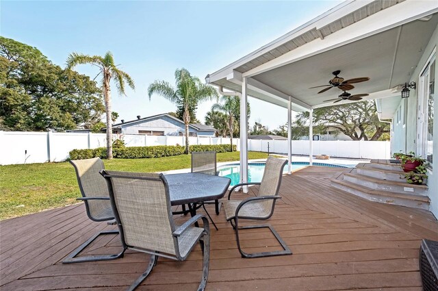 wooden terrace featuring outdoor dining area, a yard, a fenced backyard, and a fenced in pool