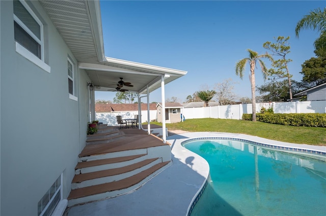 view of pool with an outbuilding, a fenced in pool, a shed, a fenced backyard, and a lawn