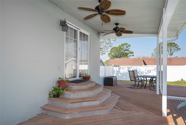 wooden deck featuring outdoor dining area, ceiling fan, and fence