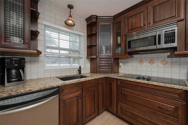 kitchen with tasteful backsplash, a sink, light stone countertops, appliances with stainless steel finishes, and open shelves