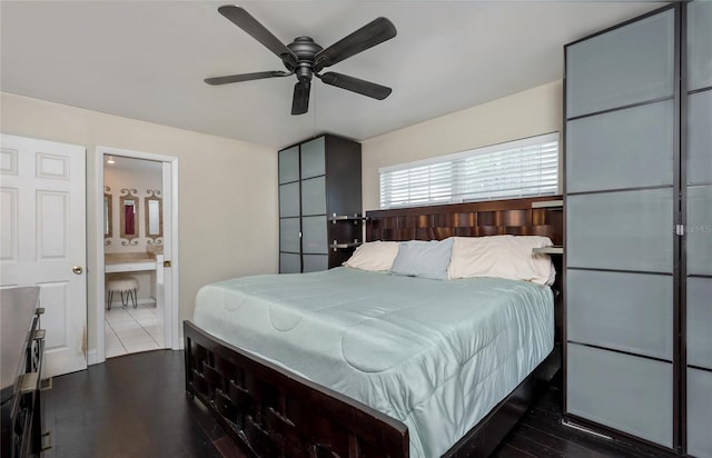 bedroom with ensuite bath, a ceiling fan, and dark wood-style flooring