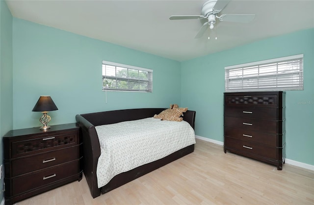 bedroom featuring a ceiling fan, baseboards, and light wood-type flooring