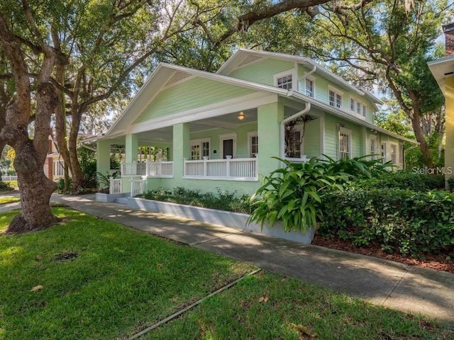 view of front facade with a front lawn, concrete driveway, and covered porch