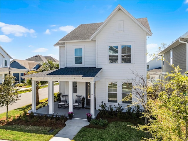 view of front of property with covered porch and roof with shingles