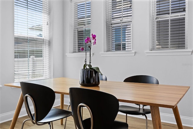 dining space with wood finished floors and baseboards