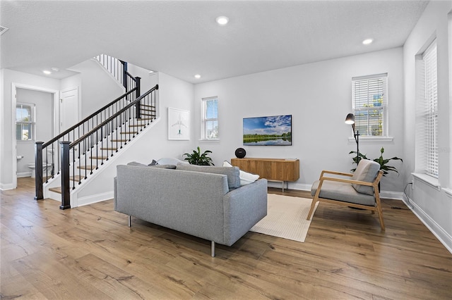 living area featuring stairs, recessed lighting, wood finished floors, and baseboards