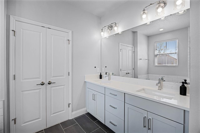 full bath with a sink, a closet, double vanity, and tile patterned flooring