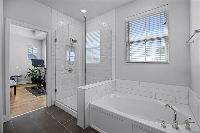 full bath featuring tile patterned floors, a stall shower, baseboards, and a garden tub