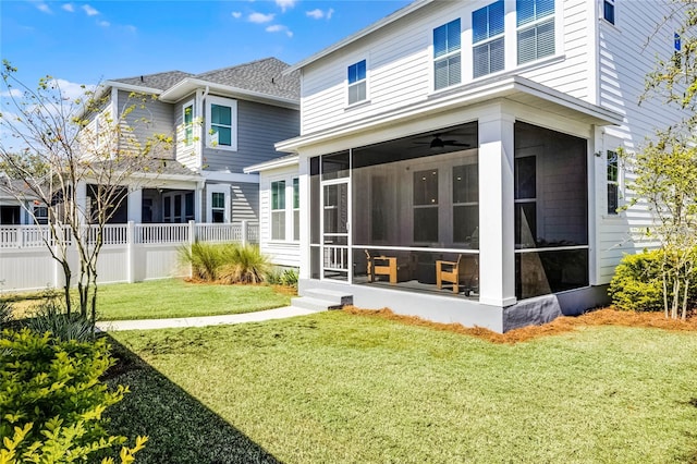 rear view of property with fence, a yard, and a sunroom