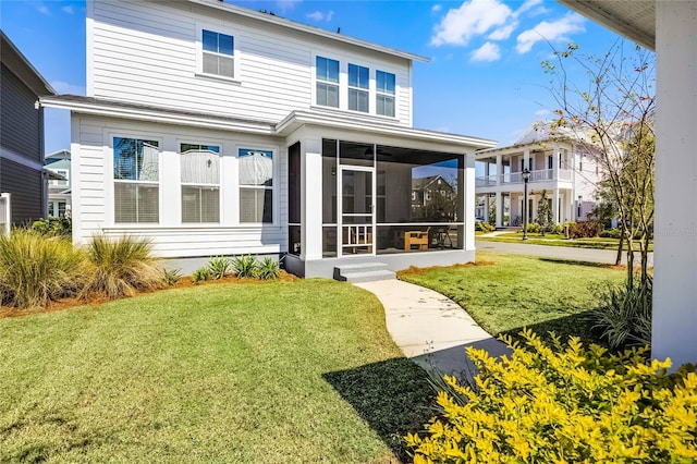 back of house with a yard and a sunroom