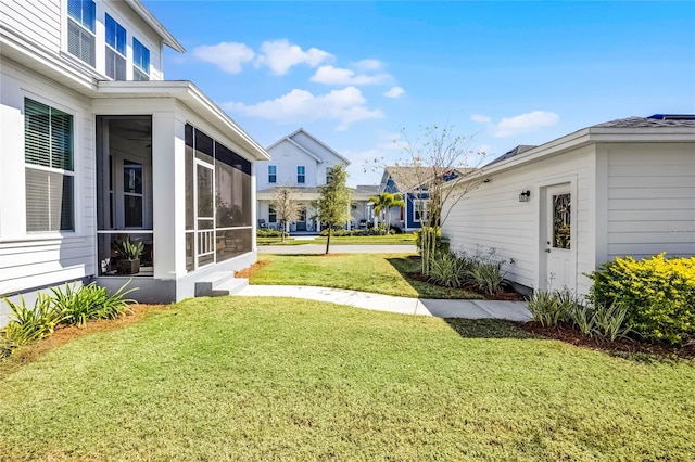 view of yard featuring a residential view and a sunroom