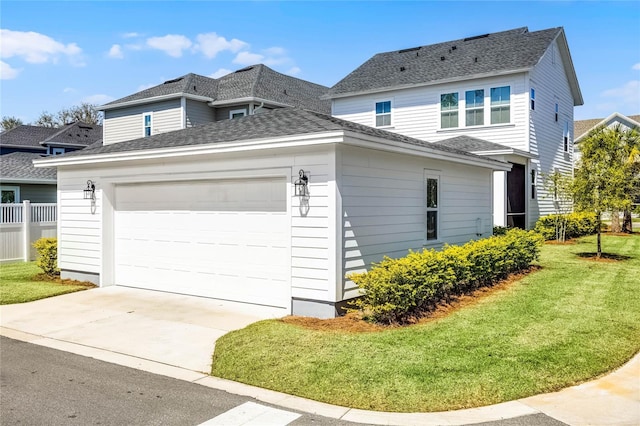 view of home's exterior featuring concrete driveway, a lawn, a garage, and roof with shingles