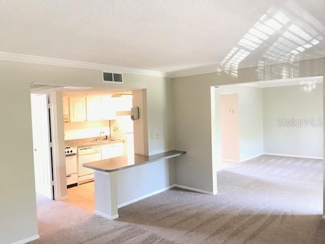 kitchen featuring visible vents, light carpet, range with electric cooktop, ornamental molding, and dishwasher