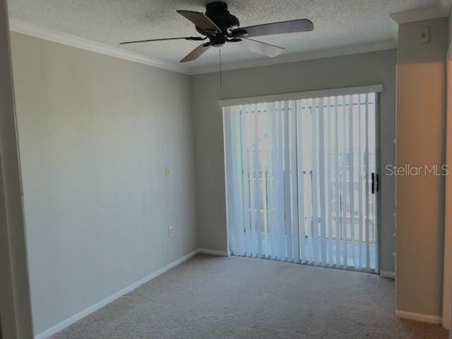 carpeted empty room with baseboards, a textured ceiling, and crown molding