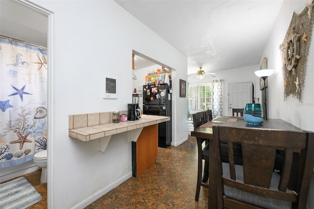 dining area with baseboards and a ceiling fan