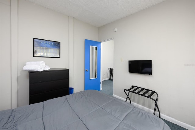 carpeted bedroom featuring baseboards and a textured ceiling