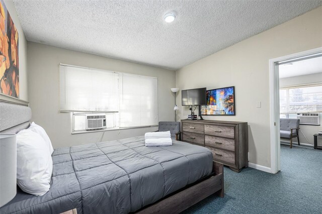 bedroom with carpet flooring, cooling unit, baseboards, and a textured ceiling