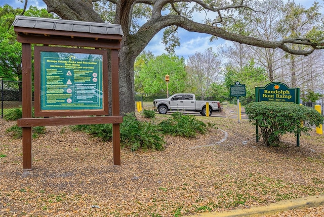 community / neighborhood sign featuring fence