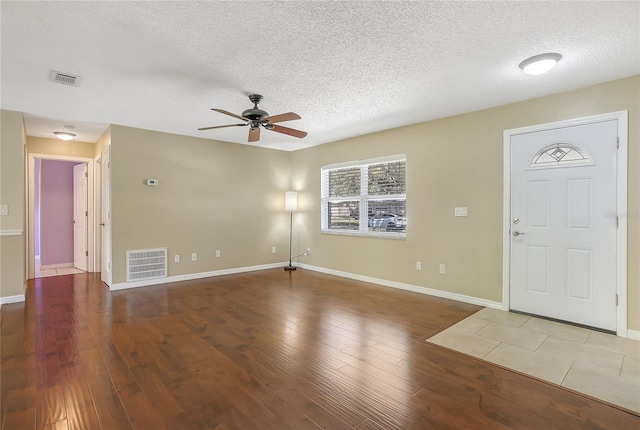 foyer with visible vents, a textured ceiling, ceiling fan, and wood finished floors