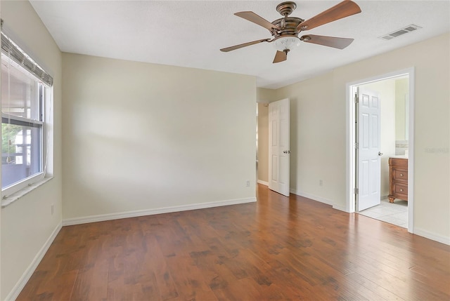 empty room with visible vents, baseboards, ceiling fan, and wood finished floors