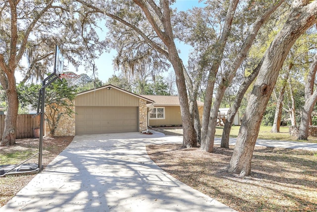 view of front of house featuring concrete driveway, a garage, and fence