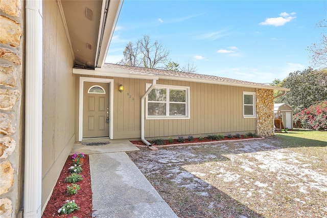 doorway to property with roof with shingles