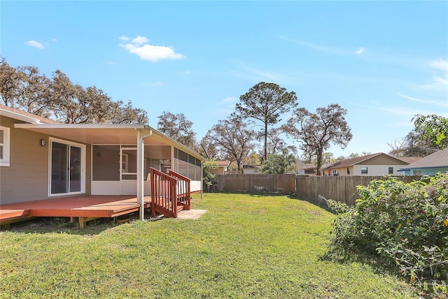 view of yard featuring a deck, a fenced backyard, and a sunroom