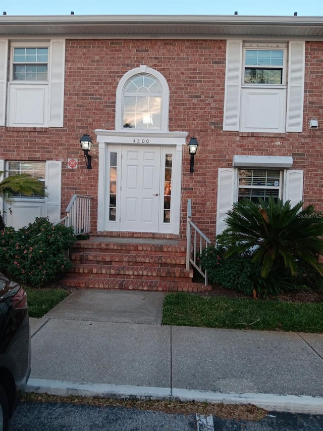 property entrance featuring brick siding